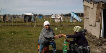 -FOTOGALERÍA: 18 de 23- AME5908\u002E GUERNICA (ARGENTINA), 18/09/2020\u002E- Dos mujeres comparten un mate el 15 de septiembre de 2020, en la toma de tierras de la localidad de Guernica, a 30 km de Buenos Aires (Argentina)\u002E Más de mil personas en condición de pobreza se instalaron desde el 20 de julio en un terreno de 100 hectáreas ubicado en Guernica, conformando la más grande toma de tierras en la provincia de Buenos Aires\u002E EFE/ Juan Ignacio Roncoroni