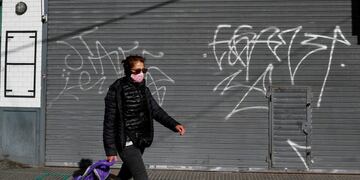 A woman wearing a face mask walks as the outbreak of the coronavirus disease (COVID-19) continues, in Buenos Aires, Argentina June 29, 2020\u002E REUTERS/Agustin Marcarian