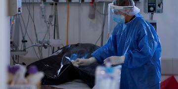 A health worker cleans the bodybag of a COVID-19 victim in the intensive care unit (ICU) of a hospital in Buenos Aires, Argentina, Tuesday, Aug\u002E 18, 2020\u002E (AP Photo/Natacha Pisarenko)   muerto coronavirus casos del dia