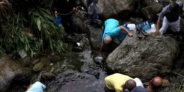 Los caraqueños juntan agua de un río contaminado