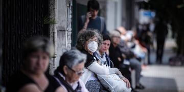 AME002\u002E BUENOS AIRES (ARGENTINA), 03/04/2020\u002E- Personas que hacen fila afuera de un banco donde pagan jubilaciones y planes sociales este viernes, en Buenos Aires (Argentina)\u002E El Gobierno de Argentina ordenó este viernes que los bancos abran sus puertas este fin de semana luego de que hoy se registraran aglomeraciones a las puertas de las entidades para poder cobrar jubilaciones y ayudas sociales en pleno aislamiento obligatorio para prevenir los contagios de COVID-19\u002E EFE/Juan Ignacio Roncoroni