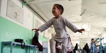 TOPSHOT - Ahmad Sayed Rahman, a five-year-old Afghan boy who lost his right leg when he was hit by a bullet in the crossfire of a battle, dances with his prosthetic leg at the International Committee of the Red Cross (ICRC) hospital for war victims and the disabled, in Kabul on May 7, 2019\u002E - With his hands in the air and an infectious grin spreading from ear to ear, a young Afghan boy whirls around a Kabul hospital room on his new prosthetic leg\u002E The boy, five-year-old Ahmad Sayed Rahman, has become a social media star in Afghanistan and beyond after a short video of him effortlessly dancing on his new limb was published this week on Twitter\u002E (Photo by WAKIL KOHSAR / AFP)