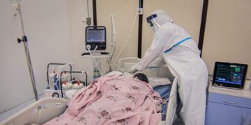 A Medical staff in Personal Protective Equipment (PPE) takes care of a patient infected by the COVID-19 (novel coronavirus) at Intensive Care Unit (ICU) at the makeshift hospital installed inside Millenium Hall, one of the country's largest event center, in Addis Ababa, on August 3, 2020\u002E (Photo by AMANUEL SILESHI / AFP)