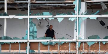 A man looks at damage inside the Capitol One Bank Tower, with its windows blown out in the downtown area after Hurricane Laura passed through on August 27, 2020 in Lake Charles, Louisiana\u002E - Hurricane Laura slammed into the southern US state of Louisiana Thursday and the monster category 4 storm prompted warnings of \
