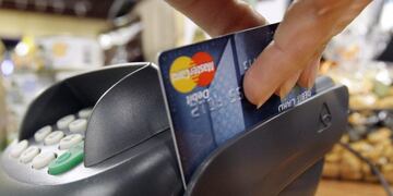 FILE - In this file photo made Nov. 2, 2009, a customer swipes a MasterCard debit card through a machine while checking-out at a shop in Seattle. Consumer spending rose slightly in May, a sign that Americans are nervous about the economy's health.(AP Phot