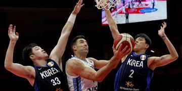 Luis Scola of Argentina, center, shoots over Lee Seounghyun, left, and Choi Junyong of South Korea during their group phase basketball game in the FIBA Basketball World Cup, at the Sport Center in Wuhan in central China's Hubei province, Saturday, Aug\u002E 31, 2019\u002E (AP Photo/Andy Wong)