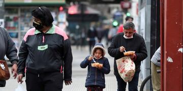Osvaldo Curahua eats next to his daughter Maria a ration of stew in a plastic container he received at a soup kitchen organized at the Caacupe church, during the coronavirus disease (COVID-19) outbreak, in Buenos Aires, Argentina July 23, 2020\u002E Picture taken July 23, 2020\u002E REUTERS/Agustin Marcarian