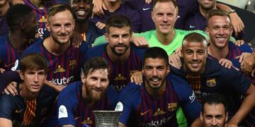 Barcelona's Argentinian forward Lionel Messi (C) carries the cup as they celebrate at the end of the Spanish Super Cup final between Sevilla FC and FC Barcelona at Ibn Batouta Stadium in the Moroccan city of Tangiers on August 12, 2018\u002E - Barcelona defeated Sevilla 2-1 to win the Spanish Super Cup\u002E (Photo by FADEL SENNA / AFP)