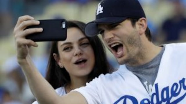 FILE- In this Oct. 19, 2016, file photo, Ashton Kutcher and wife Mila Kunis take a selfie before Game 4 of the National League baseball championship series between the Chicago Cubs and the Los Angeles Dodgers in Los Angeles. Kunis and Kutcher are parents