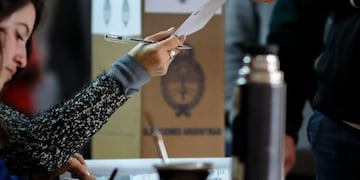 AME6109\u002E BUENOS AIRES (ARGENTINA), 11/08/2019\u002E- Un hombre recibe su papeleta electoral este domingo en Buenos Aires (Argentina)\u002E Unos 33,8 millones de argentinos deben acudir hoy a las urnas para optar entre las diez fórmulas presidenciales que en estas primarias buscan quedar habilitadas para la competencia de octubre\u002E EFE/Juan Ignacio Roncoroni