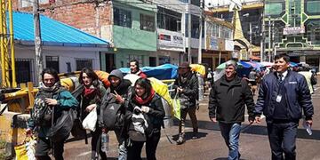 Handout photo distributed by the Peruvian Migrations Service of tourists being escorted by authorities as they walk towards the borderline with Bolivia in Desaguadero, Peru, on January 16, 2010, after they were arrested for surreptitiously entering prohibited areas of the ancient Inca citadel of Machu Picchu, and damaging the famous Temple of the Sun\u002E - A group of six tourists from Argentina, Brazil, Chile and France has been charged as the authors of the crime against cultural property, in the modality of illegal extraction of cultural property\u002E (Photo by HO / Peruvian Migrations Service / AFP) / RESTRICTED TO EDITORIAL USE - MANDATORY CREDIT \