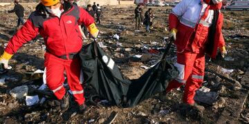 Shahriar (Iran (islamic Republic Of)), 08/01/2020\u002E- Members of the International Red Crescent collect bodies of victims around the wreckage after an Ukraine International Airlines Boeing 737-800 carrying 176 people crashed near Imam Khomeini Airport in Tehran, killing everyone on board, in Shahriar, Iran, 08 January 2020\u002E (Ucrania, Teherán) EFE/EPA/ABEDIN TAHERKENAREH