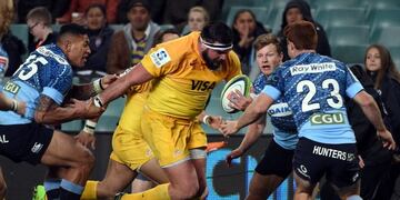 Jaguares' Ramiro Herrera (C) is tackled during the Super Rugby match between Australia's New South Wales Waratahs and Argentina's Jaguares in Sydney on July 8, 2017\u002E / AFP PHOTO / SAEED KHAN / IMAGE RESTRICTED TO EDITORIAL USE - STRICTLY NO COMMERCIAL USE