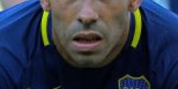 Boca Juniors forward Carlos Tevez poses wearing the Brazil's Chapecoense football team logo in his jersey to pay homage for the 71 victims of the plane crash in the Colombian mountains earlier this week, before the start of their Argentina First Division