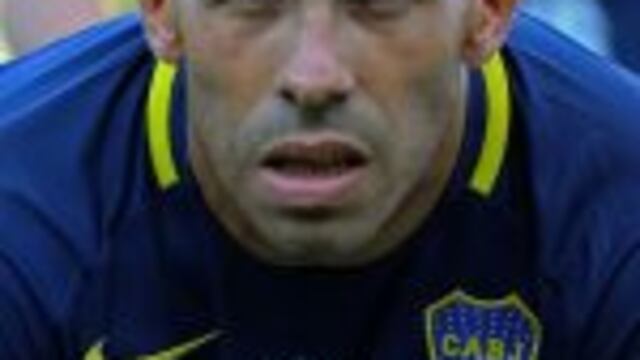 Boca Juniors forward Carlos Tevez poses wearing the Brazil's Chapecoense football team logo in his jersey to pay homage for the 71 victims of the plane crash in the Colombian mountains earlier this week, before the start of their Argentina First Division