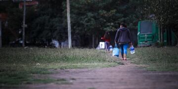 AME5995\u002E BUENOS AIRES (ARGENTINA), 27/04/2020\u002E- Personas caminan luego de recibir comida que repartieron militares argentinos durante una jornada de la cuarentena obligatoria por el coronavirus este lunes en el barrio La Matanza en Buenos Aires (Argentina)\u002E Argentina abrió este lunes una nueva etapa en su confinamiento, que se alargará hasta el 10 de mayo y que comienza con polémica por la negativa de Buenos Aires y otros grandes distritos a permitir salidas recreativas de una hora, que el Gobierno nacional había anunciado como novedad para este periodo\u002E EFE/Juan Ignacio Roncoroni