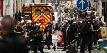 Una mujer y una niña (c) son evacuadas por las fuerzas policiales durante una supuesta toma de rehenes en la Rue des Petites Ecuries, en París (Francia)\u002E