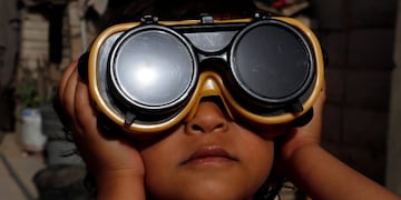 -FOTODELDIA- Sanaa (Yemen), 21/06/2020\u002E- Un niño usa anteojos protectores especiales para observar un eclipse solar parcial en Sanaa, Yemen, 21 de junio de 2020\u002E Un eclipse solar parcial ocurre cuando una porción de la Tierra está envuelta por la sombra ( penumbra) proyectada por la Luna cuando pasa entre nuestro planeta y el Sol en una alineación imperfecta\u002E EFE / YAHYA ARHAB