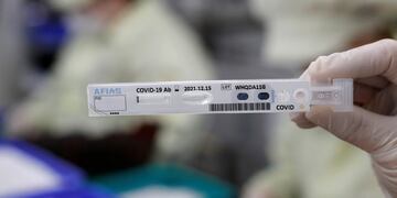 An employee holds up an antibody test cartridge of AFIAS COVID-19 Ab testing kit used in diagnosing the coronavirus for a photograph on a production line of the Boditech Med Inc\u002E in Chuncheon, South Korea, Friday, April 17, 2020\u002E Boditech Med recently started exporting its antibody-based virus test kits to various countries\u002E (AP Photo/Lee Jin-man)