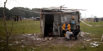 A family sits outside a makeshift home at a squatters camp in Guernica, Buenos Aires province, Argentina, Sunday, Sept\u002E 27, 2020\u002E A court has ordered the eviction of families who are squatting there since July, but the families say they have nowhere to go amid the COVID-19 pandemic\u002E (AP Photo/Natacha Pisarenko)