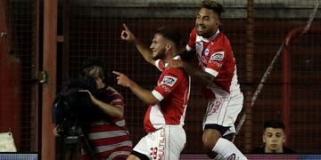 Argentinos Juniors' midfielder Alexis Mac Allister (L) celebrates with teammate Damian Batallini after scoring against Boca Juniors during their Argentina First Division Superliga football match at the Diego Armando Maradona stadium, in Buenos Aires, on March 5, 2018\u002E / AFP PHOTO / Alejandro PAGNI