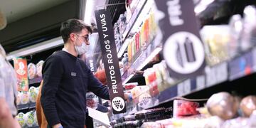 GRAF976\u002E MADRID, 24/03/2020\u002E- Varias personas hacen la compra con mascarilla y guantes en un supermercado en Madrid este martes durante la segunda semana de aislamiento decretado para frenar el avance del coronavirus\u002E EFE/Rodrigo Jiménez