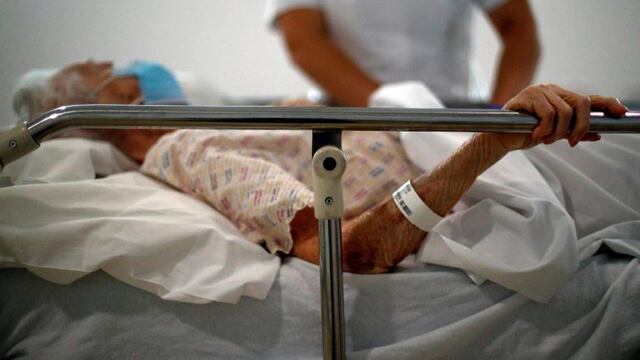 ID:42497459 Patient Doreen Mount is comforted by a Radiologist in the X-ray department at the Royal Blackburn Teaching Hospital in Blackburn, north-west England on May 14, 2020, as national health service (NHS) staff in Britain fight the novel coronavirus COVID-19 pandemic\u002E (Photo by HANNAH MCKAY / POOL / AFP) anciano ancianos anciana abuelo abuela enfermera enfermero manos