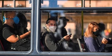 Trabajadores esenciales viajando en colectivo en Buenos Aires (RONALDO SCHEMIDT / AFP)