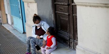 A woman and child sit on a door stoop in Buenos Aires, Argentina, Saturday, May 16, 2020\u002E Children in the Argentine capital are now allowed limited outdoor recreation time on weekends for the first time since quarantine measures to help curb the spread of COVID-19 were put in place almost 2 months ago\u002E (AP Photo/Natacha Pisarenko)