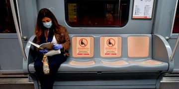 27 April 2020, Italy, Milan: A woman wearing a face mask sits on the metro next to three empty seats to maintain her social distance as part of precautions taken against the coronavirus\u002E Photo: Claudio Furlan/LaPresse via ZUMA Press/dpa