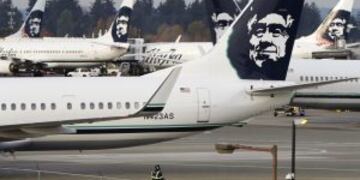 A ground crew member walks near Alaska Airlines planes parked at Seattle-Tacoma International Airport in SeaTac, Washington October 30, 2013. Voters in the working-class Seattle suburb of SeaTac, which encompasses the region's main airport, will decide on