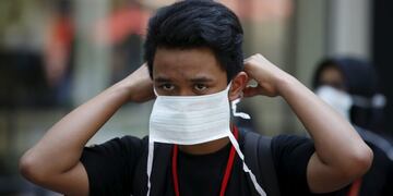 A tourist puts on a face mask to prevent contracting Middle East Respiratory Syndrome (MERS) at Myeongdong shopping district in central Seoul, South Korea, June 10, 2015\u002E South Korean President postponed a U\u002ES\u002E visit on Wednesday to supervise the handling of an outbreak of Middle East Respiratory Syndrome (MERS), as two more people died and 13 new cases were reported, lifting the total number of patients to 108\u002E REUTERS/Kim Hong-Ji corea del sur brote del Sindrome Respiratorio Oriente Medio gente en la calle ciudad con barbijo contaminacion