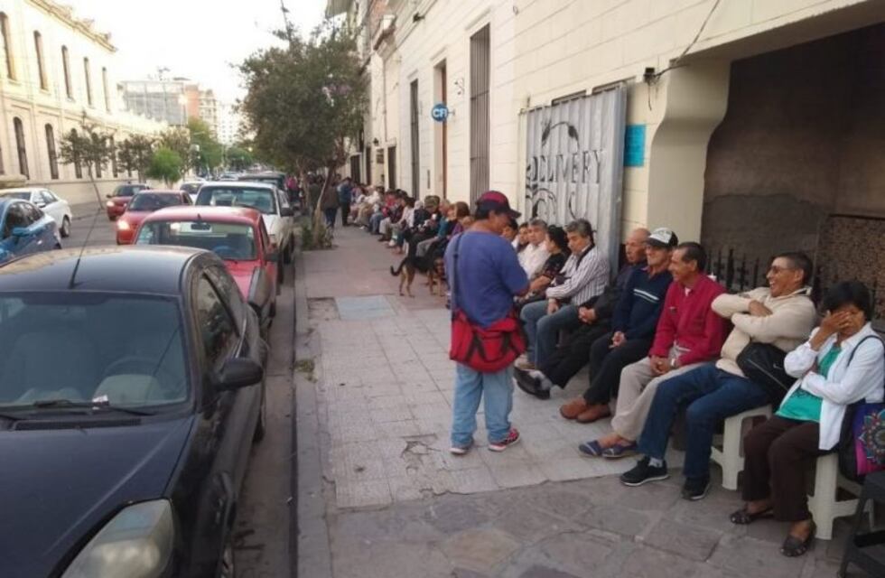 Una pareja le alquila banquetas a jubilados mientras hacen la fila para cobrar