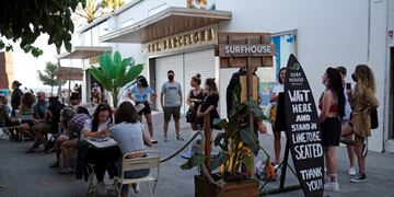 People sit at a bar near Barceloneta beach, after Catalonia's regional authorities and the city council announced restrictions to contain the spread of the coronavirus disease (COVID-19) in Barcelona, Spain July 19, 2020\u002E REUTERS/Nacho Doce