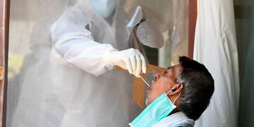 A health official collects a swab sample from a man to test for the COVID-19 coronavirus after authorities eased restrictions imposed as a preventive measure against the spread of the COVID-19 coronavirus, in New Delhi on June 16, 2020\u002E (Photo by Sajjad HUSSAIN / AFP)