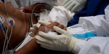 Spanish health workers and volunteers of the SAMU Foundation fight together with Salvadoran doctors to save the life of patient affected by the novel coronavirus, COVID-19, at the intensive care unit of El Salvador Hospital, in San Salvador, on August 12, 2020\u002E (Photo by Yuri CORTEZ / AFP)