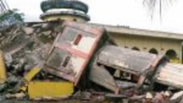 TOPSHOT - Residents gather outside a damaged mosque, its minaret reduced to rubble following its collapse, after a 6.5-magnitude earthquake struck the town of Pidie, Indonesia's Aceh province in northern Sumatra, on December 7, 2016.nOne person died and dozens were feared trapped in rubble after a strong earthquake struck off Aceh province on Indonesia's Sumatra island on December 7, officials said.  / AFP PHOTO / ZIAN MUTTAQIEN