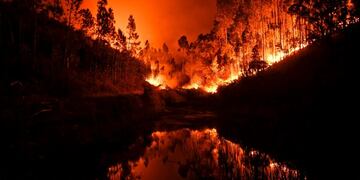 TOPSHOT - A wildfire is reflected in a stream at Penela, Coimbra, central Portugal, on June 18, 2017\u002E \nA wildfire in central Portugal killed at least 25 people and injured 16 others, most of them burning to death in their cars, the government said on June 18, 2017\u002E Several hundred firefighters and 160 vehicles were dispatched late on June 17 to tackle the blaze, which broke out in the afternoon in the municipality of Pedrogao Grande before spreading fast across several fronts\u002E / AFP PHOTO / PATRICIA DE MELO MOREIRA