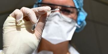 A health official shows a nasal swab sample for a Covid-19 coronavirus test in a \