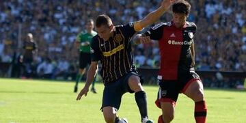 Marco Ruben y Sebastiu00e1n Domu00ednguez disputan la pelota en el clu00e1sico entre Newell's y Central.