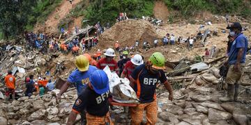 Rescuers carry a body bag containing a landslide victim, triggered by heavy rains during Typhoon Mangkhut, in Itogon, Benguet province on September 18, 2018\u002E - Hundreds of Philippine rescuers used shovels and their bare hands on September 18 to sift through a massive landslide, with dozens feared dead in the region worst-hit by Typhoon Mangkhut as the storm's toll climbed to 74\u002E (Photo by TED ALJIBE / AFP)