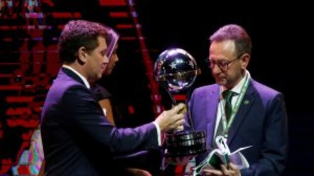 Conmebol President Alejandro Dominguez, left, presents the Sudamericana Championship trophy to Brazil's Chapecoense President Plinio de Nes during a Copa Libertadores soccer championship drawing ceremony, in Luque, Paraguay, Wednesday, Dec. 21, 2016. The first round of 58th edition of this championship will start on Jan. 23, 2017. (AP Photo/Jorge Saenz)