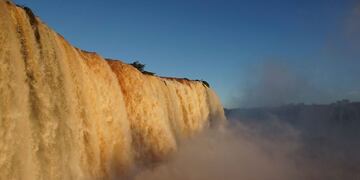 TOPSHOT - Picture of the Iguacu (Iguazu) falls -considered as one of the largest waterfalls in the world- as seen from the Brazilian side on the border with Argentina, near Foz do Iguacu, on June 4, 2019\u002E - The quantity of water falling from the Iguacu falls at the border between Argentina and Brazil has doubled these last few days following heavy rains in the region\u002E While the average flow rate of the falls is usually 1,5 million liters of water per second, the currently rate is at 3 million\u002E (Photo by Christian RIZZI / AFP)