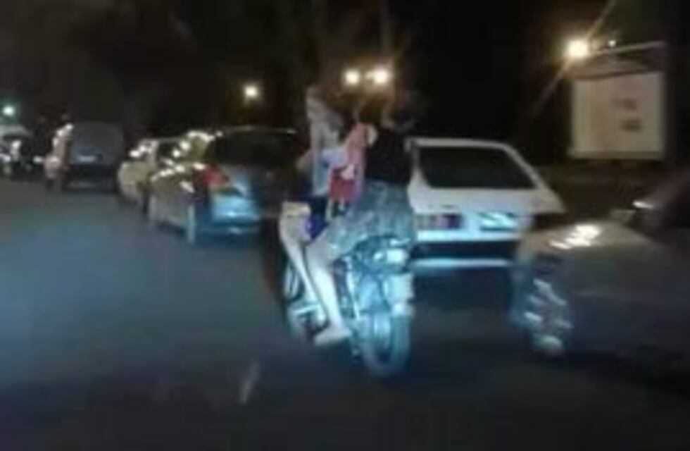Iban tres en una moto, sin luces ni casco, y con una nena parada y bailando