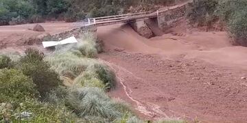 Evidenciando la fuerza del alud, a la izquierda de la imagen se advierte una enorme roca que es fácilmente arrastrada por la corriente acercándose a uno de los puentes que permiten el acceso a Caspalá, en el departamento jujeño Valle Grande.