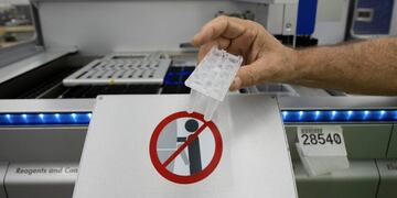 Steve Frueh works on a QIAGEN QIAsymphony, a product that is used for the coronavirus disease (COVID-19) testing, at the bio-tech company New Life Scientific in Cridersville, Ohio, U\u002ES\u002E, August 24, 2020\u002E  REUTERS/Seth Herald