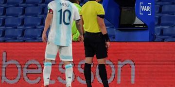 Lionel Messi mira el VAR junto al árbitro brasileño Raphael Claus en el partido ante Paraguay por las Eliminatorias para Qatar 2022 (Marcelo Endelli / AFP)
