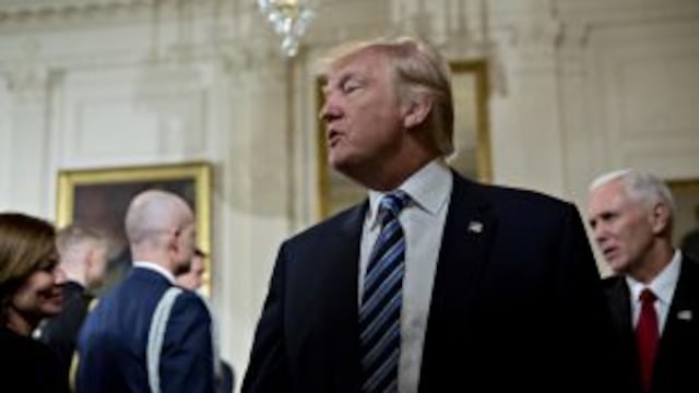 U.S. President Donald Trump walks out with U.S. Vice President Mike Pence, right, during a swearing in ceremony of White House senior staff in the East Room of the White House in Washington, D.C., U.S., on Sunday, Jan. 22, 2017. Trump today mocked protest