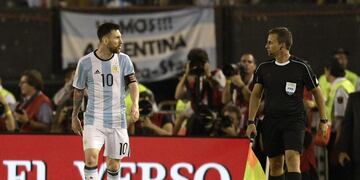 Argentina's forward Lionel Messi (L) argues with first assistant referee Emerson Augusto de Carvalho during the half time of their 2018 FIFA World Cup Russia South American qualifier football match against Chile, at the Monumental stadium in Buenos Aires,