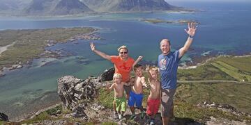 NOR01 ARCHIPIu00c9LAGO DE LOFOTEN (NORUEGA) 20/03/2017.- Una familia celebra en lo alto de una montau00f1a en el archipiu00e9lago de Lofoten, en Noruega, el 19 de julio de 2014. Con una puntuaciu00f3n de 7,537 sobre diez, Noruega es el pau00eds mu00e1s feliz del mundo segu00fan el I